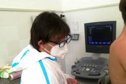 Imagen de un profesional sanitario haciendo una ecografía pulmonar a un paciente.