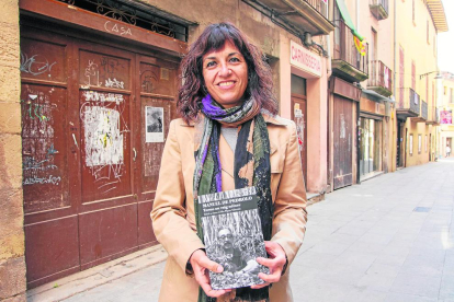 Alba Pijuan, amb el llibre davant la casa familiar de Pedrolo a Tàrrega on es van trobar els poemes.