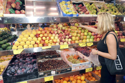 Foto de archivo de una mujer comprando fruta en un supermercado.