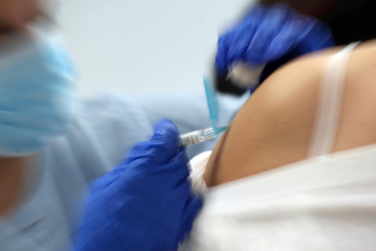 Un infermer posa una vacuna.