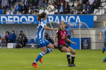Julia Miró, que acabó el partido con un vendaje en la cabeza, intenta robarle el balón a una rival.