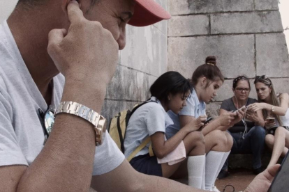 Un grup de persones es concentren en un punt wifi, a Cuba.