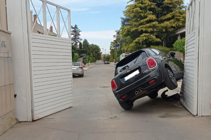 Un coche queda semivolcado en la entrada de un parking en Lleida
