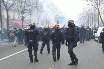 Los policías tratan de contener a los bomberos que se manifestaron ayer por las calles de París.