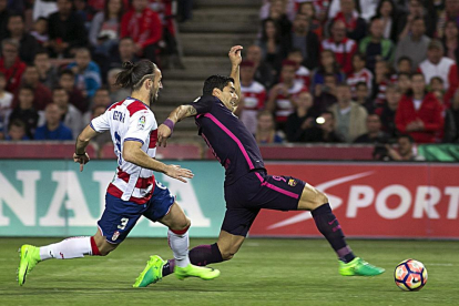 Luis Suárez remata el balón perseguido por un jugador del Granada.