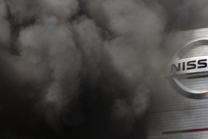 Entrada de la fábrica de Nissan en la Zona Franca de Barcelona, rodeada por el humo, durante las protestas del año pasado