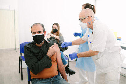 Un sanitario inocula con el fármaco de AstraZeneca a un profesor en Barcelona.