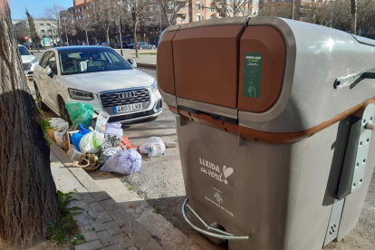 Bosses d’escombraries ahir, al costat d’un dels nous contenidors d’orgànica, que s’utilitzen amb clau.