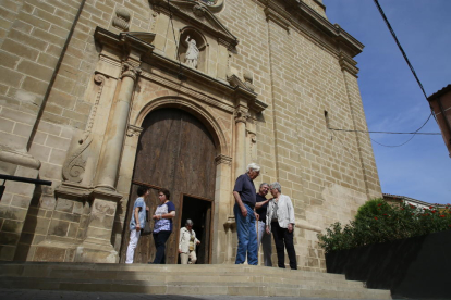 Feligresos de Benavent a la sortida de l’església, la façana de la qual presideix la controvertida escultura.