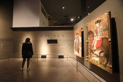 Una visitant del Museu de Lleida contempla una de les parets buides després del trasllat de les obres.