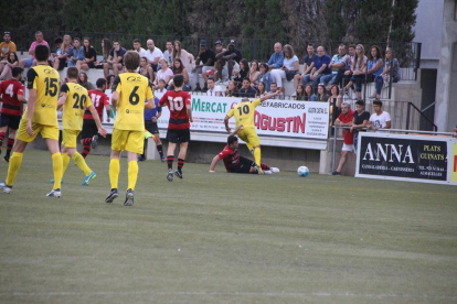 Un jugador del EFAC Almacelles pasa el balón ante la atenta mirada de un contrario y del colegiado.