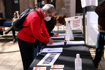 Dos persones firmant a favor de la llei d’amnistia, ahir, a Barcelona.