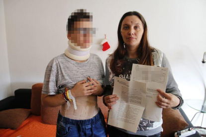 La víctima, ayer, junto a su madre, que muestra la denuncia y el informe de lesiones.