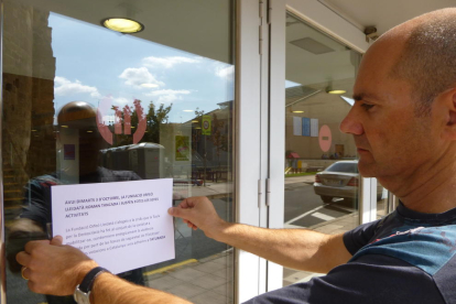 Xavier Quinquillà, pegando ayer el cartel en la puerta del Orfeó Lleidatà anunciando el cierre del centro.