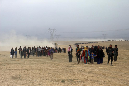 Desplaçats caminen cap a un punt de control fora de Mossul.