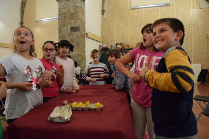 Niños jugando a uno de los juegos de mesa (izquierda) y otros participantes escogiendo entre las múltiples propuestas.