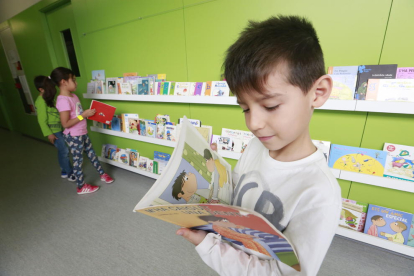 Un nen, fent una ullada a un dels llibres exposats als passadissos.