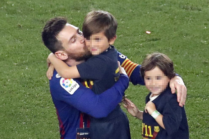 Leo, junto a dos de sus hijos en el césped del Camp Nou.