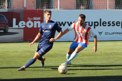 El jugador del Atlétic Lleida Pere Pons intenta despejar el balón ante el acoso de un rival.