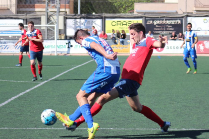 El jugador del Balaguer Pau intenta robar la pilota a un futbolista del Vilanova i la Geltrú al centre del camp.