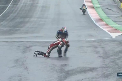 Àlex Márquez ajuda un rival després d'una caiguda al final de recta.