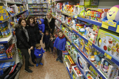 Compradors, petits i grans, comparant joguets ahir en una botiga de la Zona Alta.