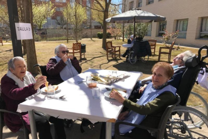 Usuaris i treballadors del Centre Geriàtric Lleida van menjar ahir calçots. A la imatge superior esquerra, Amadora, de 99 anys.