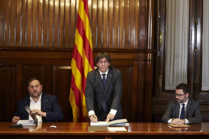 El president, Carles Puigdemont, firma la convocatòria del referèndum al costat del vicepresident, Oriol Junqueras.