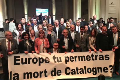 Los 200 alcaldes que viajaron a Bruselas (en primera fila, el de Cervera, Ramon Royes) desplegaron una pancarta delante de la sede de la Comisión Europea.