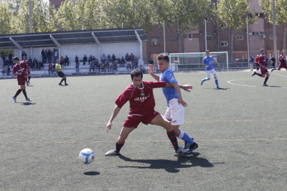 Un jugador del Lleida Esportiu B controla la pilota davant d’un futbolista del Suburenc.