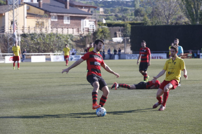 Un jugador de l’EFAC Almacelles atura la pilota amb un company estirat al fons.