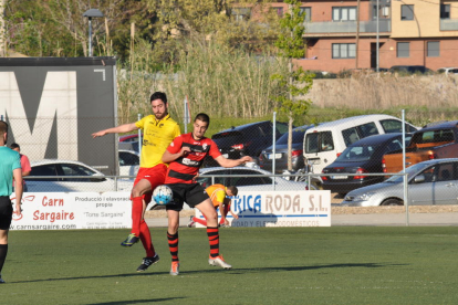 Un jugador del EFAC Almacelles detiene el balón con un compañero tendido al fondo.