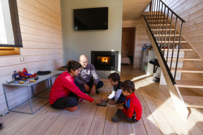 Una família juga en un bungalou amb llar de foc.