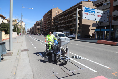 Un operari acaba de pintar la senyalització del nou carril bici, ahir al matí.