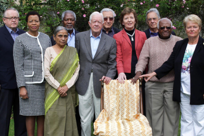 Els exlíders mundials membres de The Elders posen amb la cadira buida que va deixar Nelson Mandela.