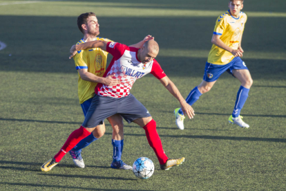 Adrià defensa la pilota davant la pressió d’un jugador del Vila-seca.