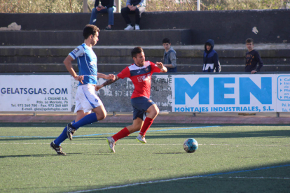 El jugador local Sergi protegeix la pilota davant la pressió d’un jugador visitant, en el partit disputat entre el Balaguer i el Morell.