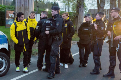 Jugadores del Borussia Dortmund junto a policías fuertemente armados después del atentado contra el autobús del equipo.