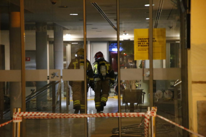Dos bombers, ahir a la nit, a l’interior del CaixaForum poc després que comencés l’incendi.