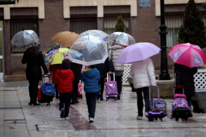 Varias personas caminan por Ciudad Real con paraguas.