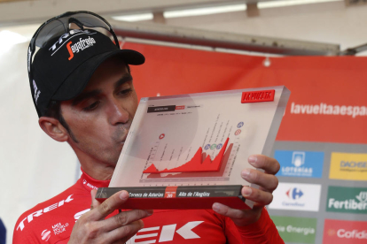 El madrileño Alberto Contador besa el trofeo de ganador de la vigésima etapa, en la que se impuso por delante de Poels y Froome.