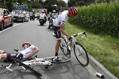 Alberto Contador vuelve a su bicicleta tras caerse junto a su compañero Michael Gogl.