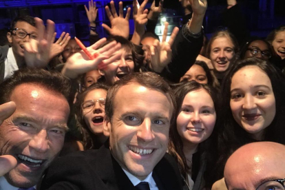 Macron, ayer con Schwarzenegger, y un grupo de adolescentes.