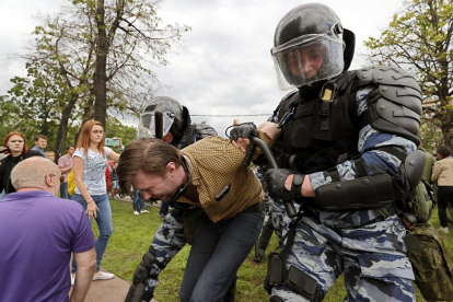 Miembros de la policía detienen a uno de los participantes en la protesta celebrada el lunes en Moscú.