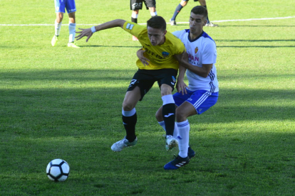 Joan Vicente agarrado por un jugador del Deportivo Aragón, en una acción del partido de ayer.