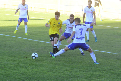 Joan Vicente agarrado por un jugador del Deportivo Aragón, en una acción del partido de ayer.
