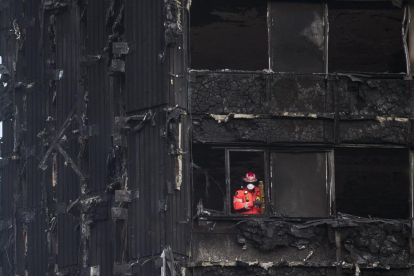 Un bomber inspecciona les restes de la torre residencial de Londres.