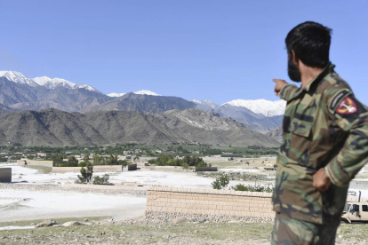 Un militar afgano indica la zona sobre la que EEUU lanzó la bomba.