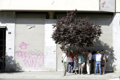 Un grupo de leridanos se refugia en la sombra de un árbol en la avenida de Les Garrigues.