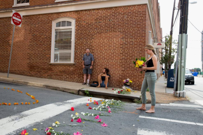 Una jove diposita flors al lloc de l’atropellament mortal a Charlottesville (Virgínia).